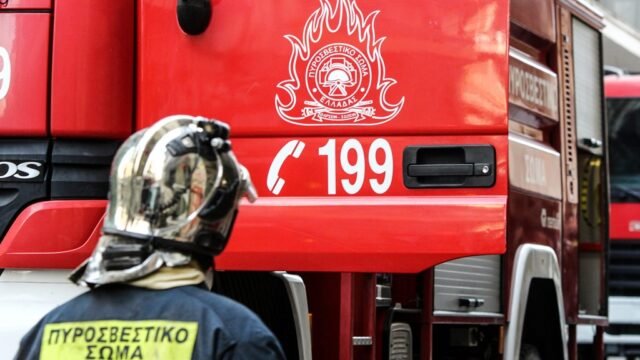 πυροσβέστης μπροστά σε όχημα της πυροσβεστικής